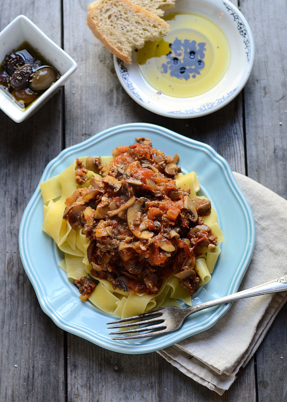 A blue plate with Hearty Pasta Sauce From Scratch on a wooden surface.