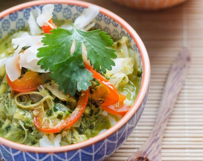 A bowl of coconut chicken curry soup over rice.