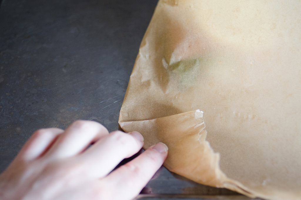 Starting to fold the piece of parchment paper up.