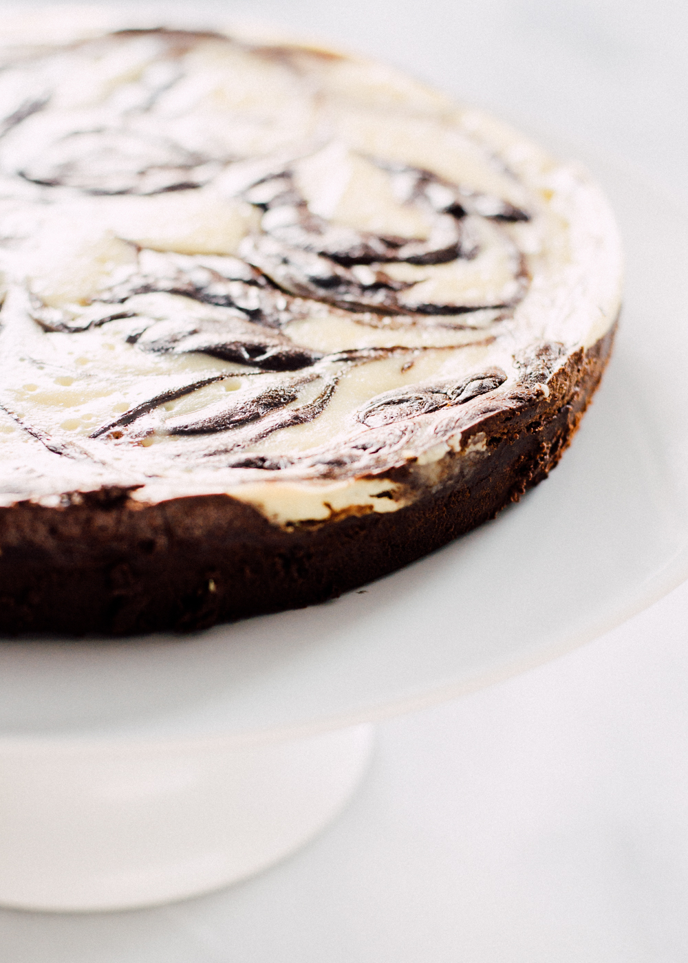 The finished chocolate marble cheesecake on a cake stand ready to be served. 