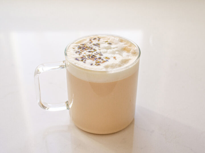 A London Fog Tea Latte in a clear glass mug.