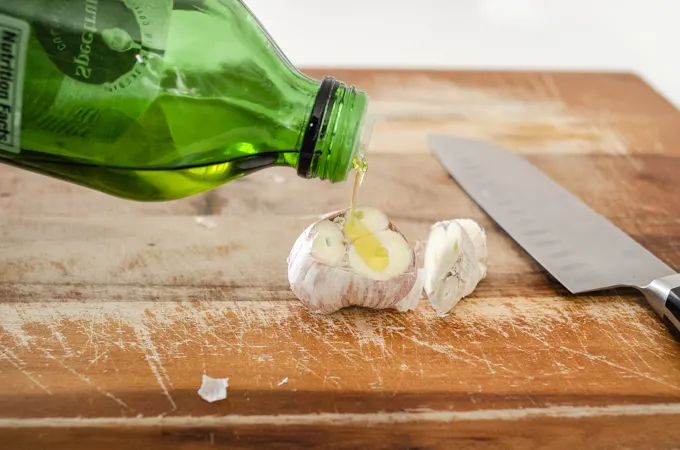 Drizzling olive oil on top.