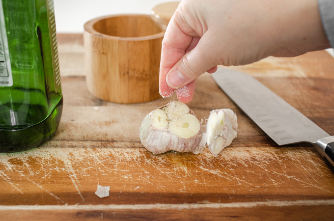 Sprinkling salt on the head of garlic before roasting it.