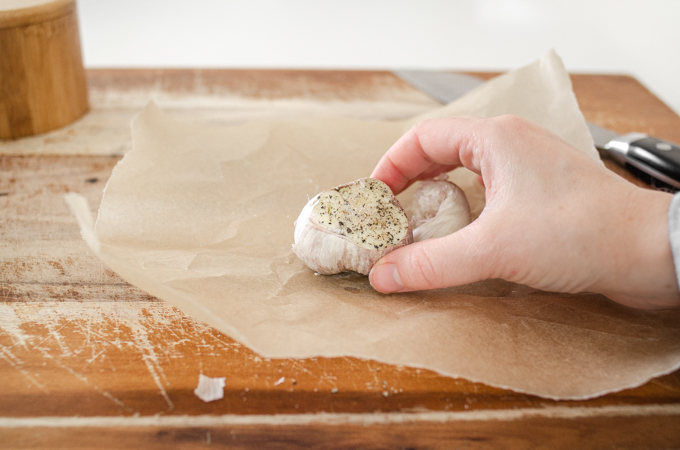 Putting a head of garlic on some parchment paper.