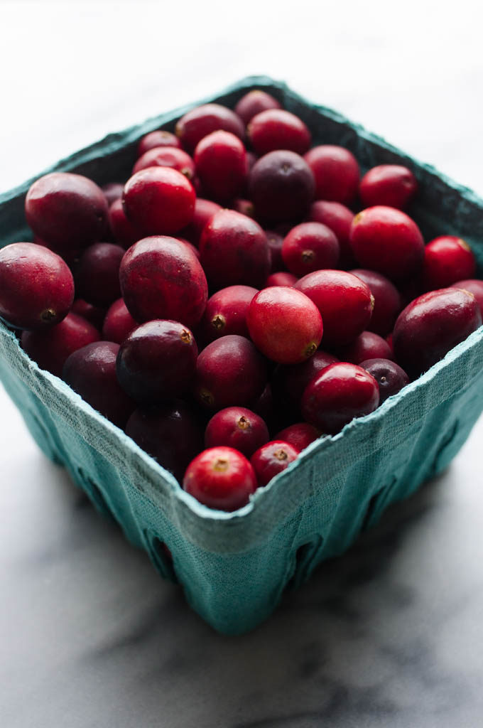 Fresh cranberries in an aqua produce basket. 