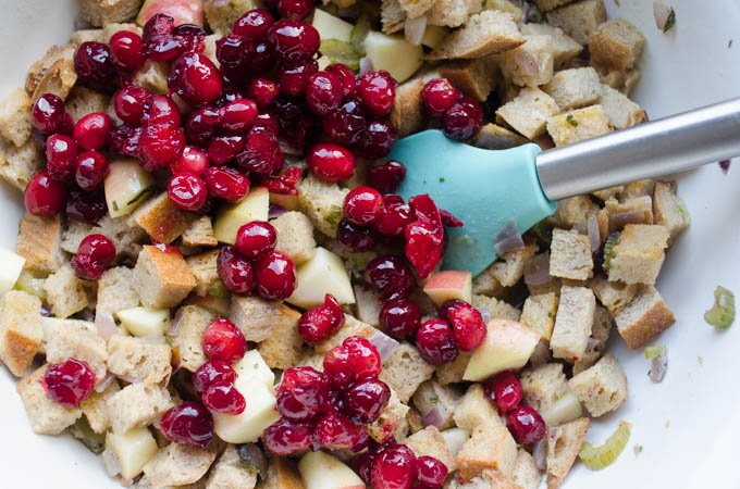 All of the ingredients for the sourdough stuffing in a large bowl with a spatula off to the side.