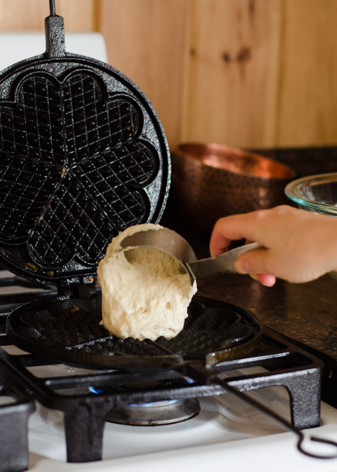 Adding the batter to the waffle iron.