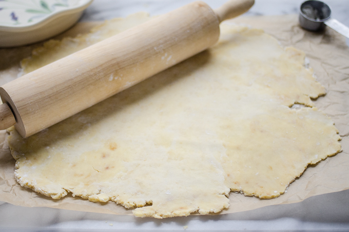 Rolling out the crust on parchment paper.