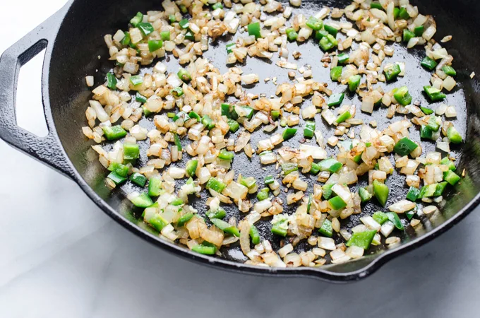 Cast iron skillet with sauteed onion and green peppers