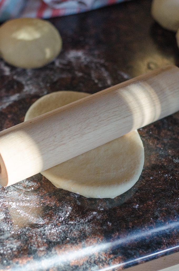 Rolling the dough into an elongated oval. 