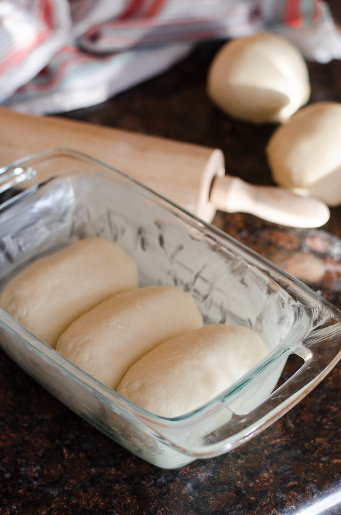 Placing the dough into a buttered pan. 