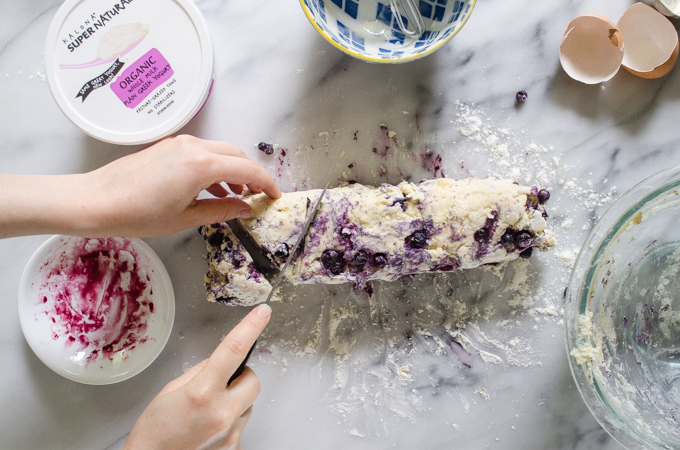 Slicing the dough into triangles with a knife.