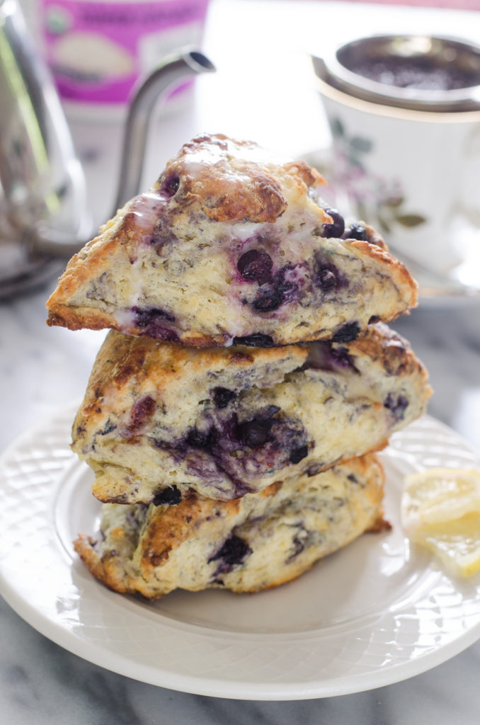 Stack of three scones on a plate drizzled with glaze.