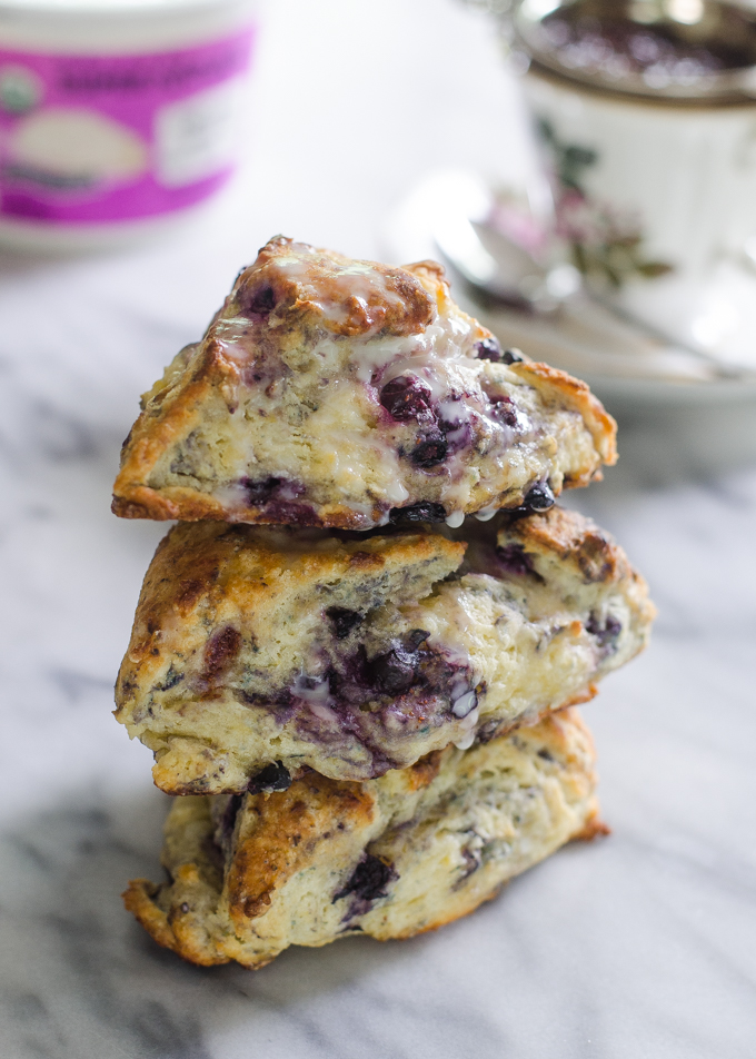 Stack of three scones on a plate drizzled with glaze.