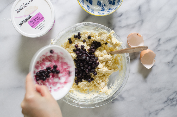 Pouring frozen wild blueberries into the dough.