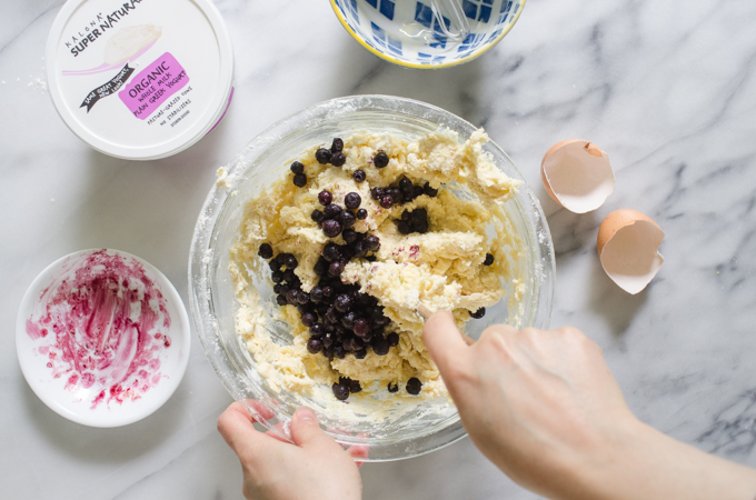 Gently mixing the scone dough to incorporate the blueberries.