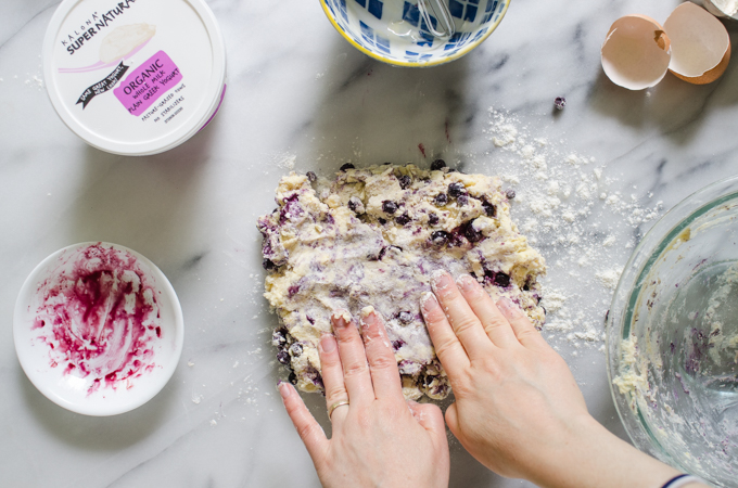 Patting the dough out into a rectangle on a marble surface.