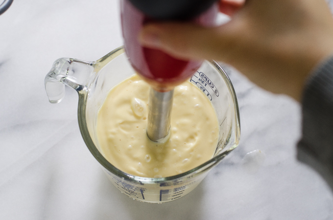 Using a stick blender to make mayonnaise.