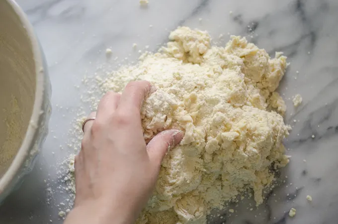 Dough dumped out on a marble work surface.
