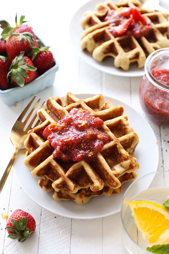 Waffles on plates with jam on top.