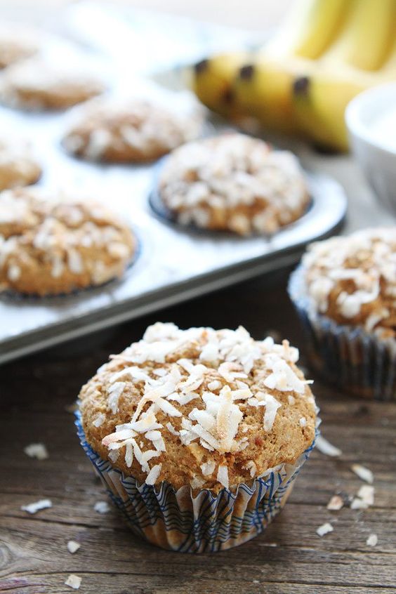 Banana coconut muffin sitting next to a muffin tin.