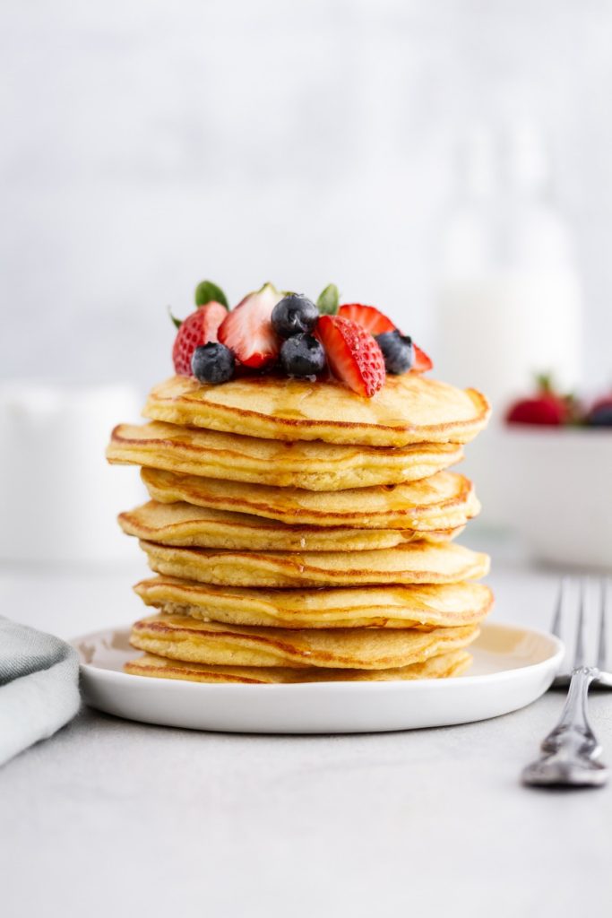 Stack of coconut flour pancakes with fresh berries on top.