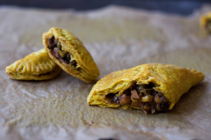 Veggie patties torn in half on a piece of parchment paper.