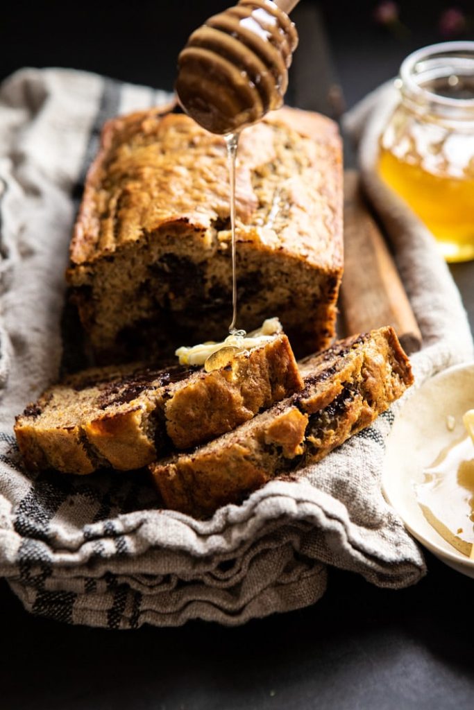 Slices of banana bread being drizzled with honey.