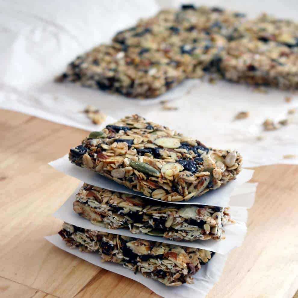 Stack of granola bars with pieces of parchment paper between them.