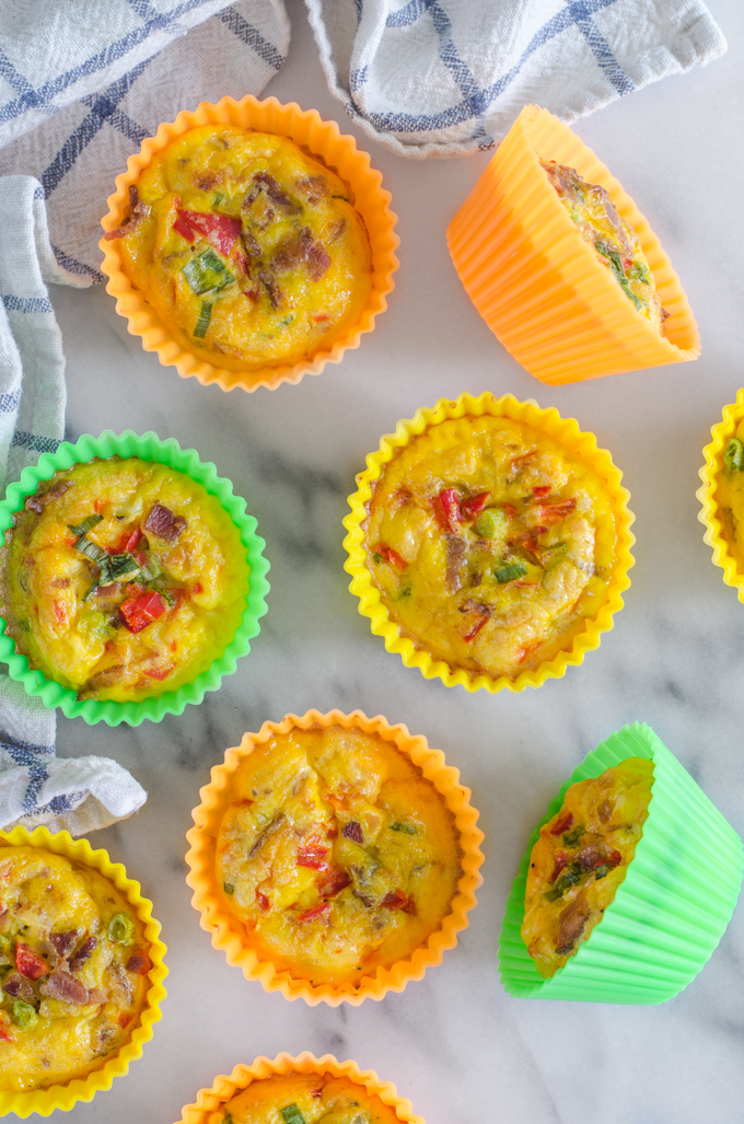 From above shot of several egg muffin cups on a marble surface with a checked tea towel.