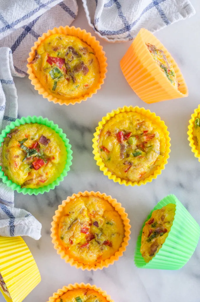 From above shot of several egg muffin cups on a marble surface with a checked tea towel.