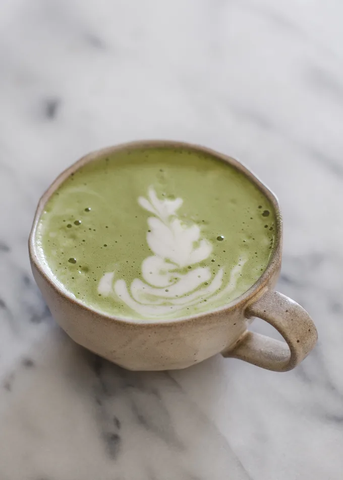 Matcha latte in a stoneware mug with latte art.