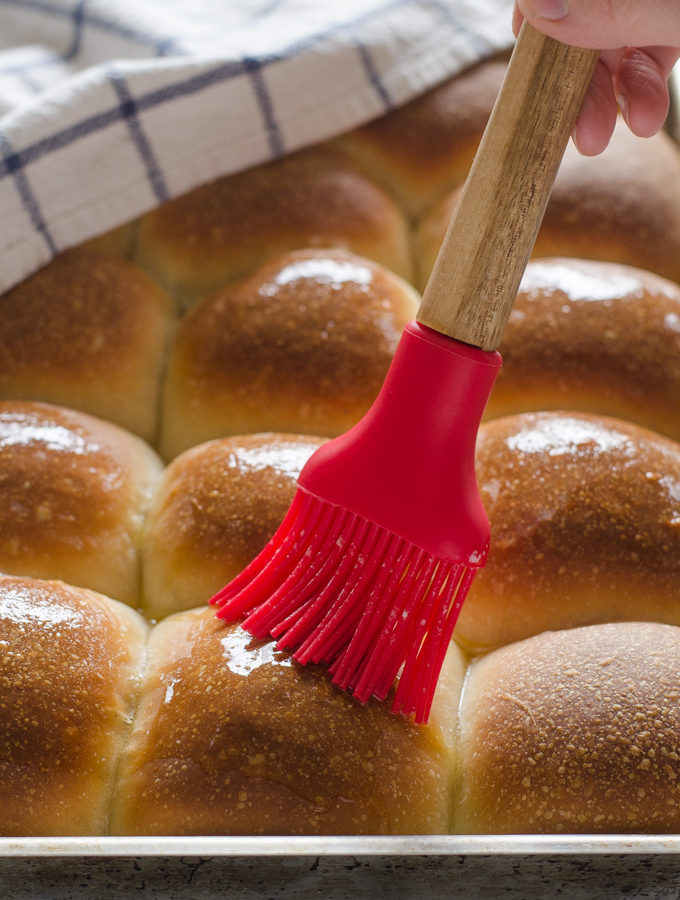 Brushing Sourdough Pull Apart Rolls with melted butter.
