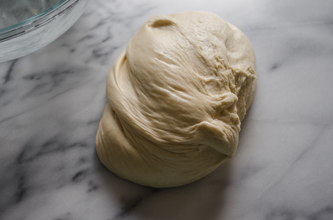 The ball of dough on a marble surface.