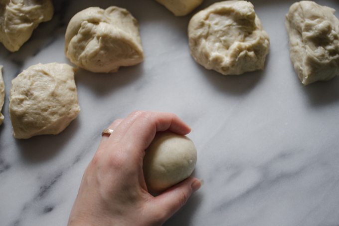 Rolling the dough to create surface tension.