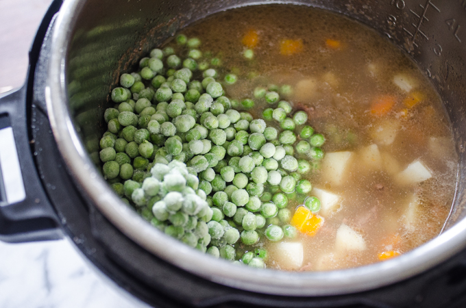 Adding the green peas to the Instant Pot Beef Stew.