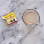 A measuring cup with the water and yeast proofing.