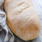 A loaf of Soft Sourdough French Bread No Yeast all baked and on a cooling rack.