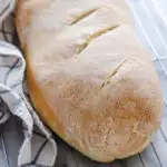 A loaf of Soft Sourdough French Bread No Yeast all baked and on a cooling rack.