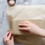 Folding parchment paper around the outside of a pan to make it fit better.