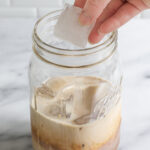 Adding ice to a mason jar.