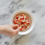 Adding the strawberries and almonds to the chocolate yogurt.