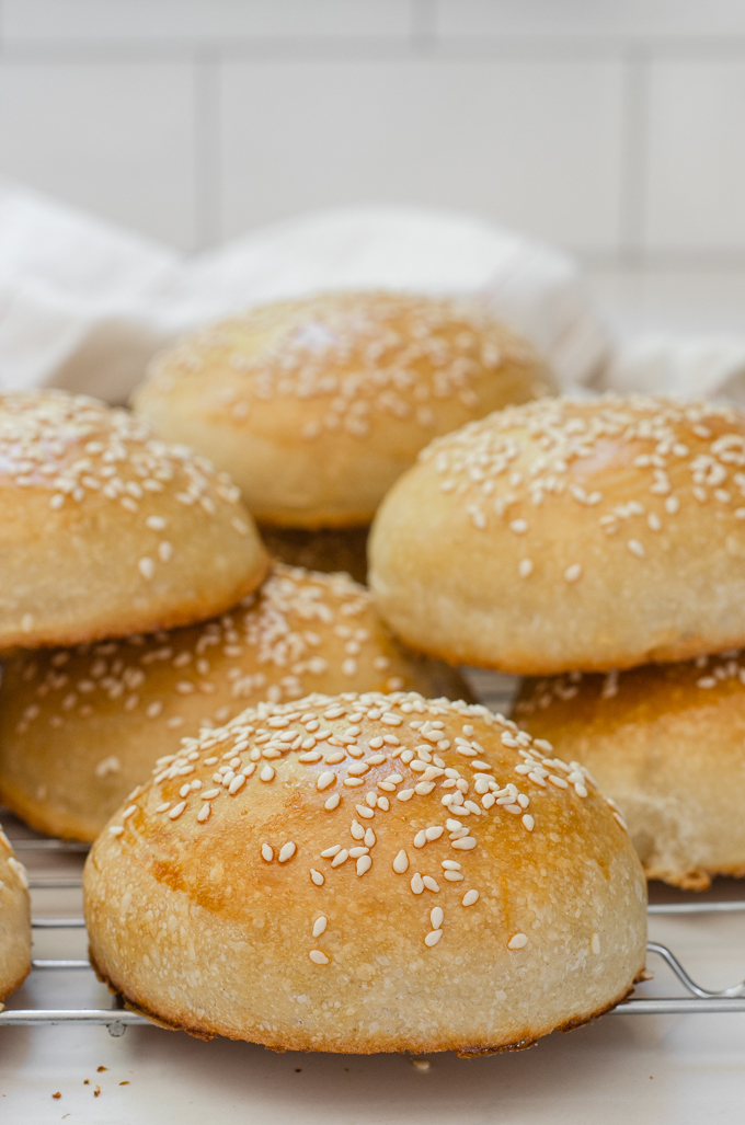 Sourdough hamburger buns on a cooling rack.