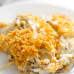 A close up shot of a plate of gluten free cheesy potatoes (AKA funeral potatoes).