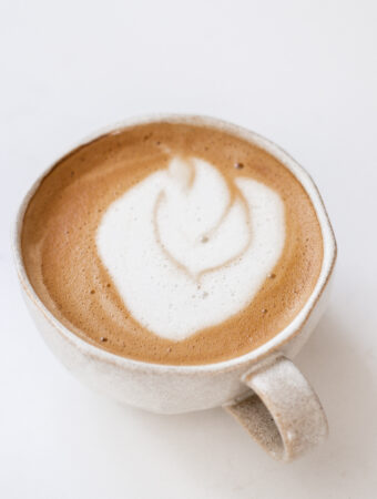 An oat milk latte in a stoneware mug.