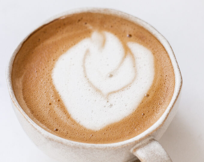 An oat milk latte in a stoneware mug.