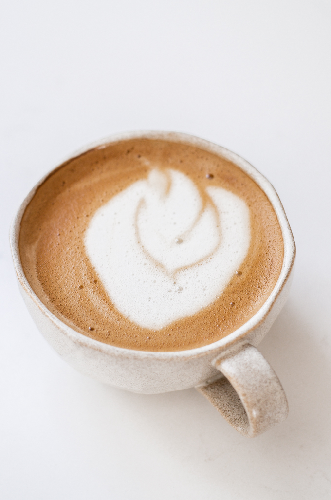 An oat milk latte in a stoneware mug.