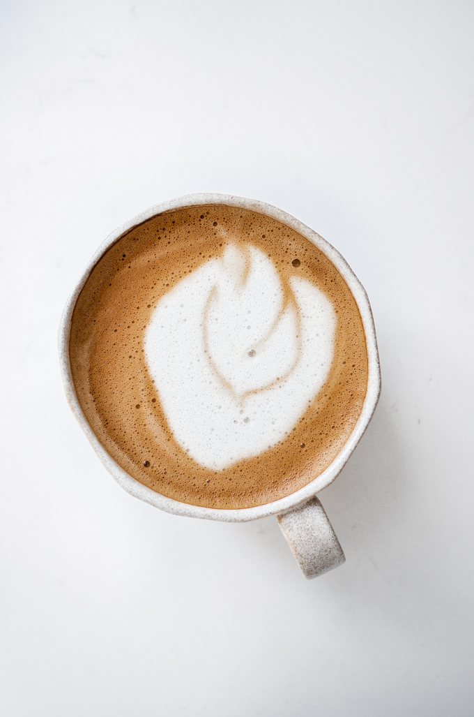 An oat milk latte in a stoneware mug.