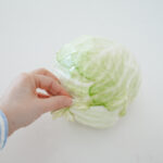 Removing the outer leaves of a head of cabbage for making spicy sauerkraut.