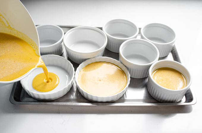 Pouring the pumpkin custard into ramekins. 